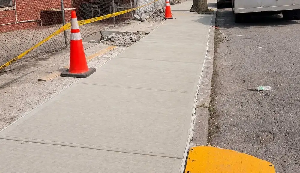 newly replaced concrete sidewalk flags after tree root damage repair in morris park
